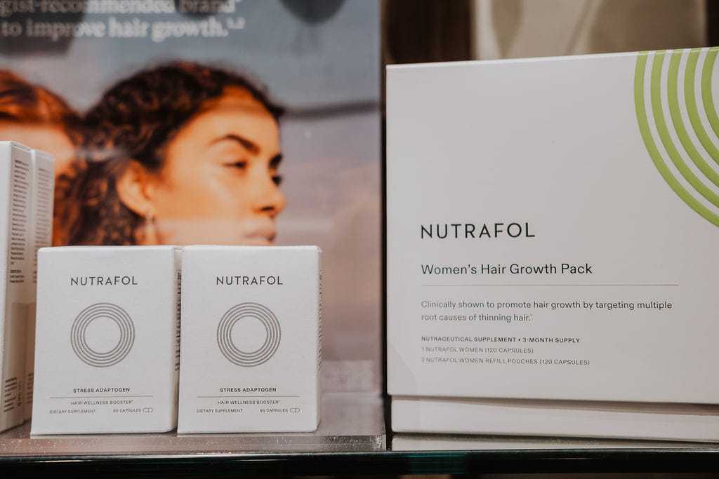 Nutrafol Women's Hair Growth Pack and supplements displayed on a shelf.