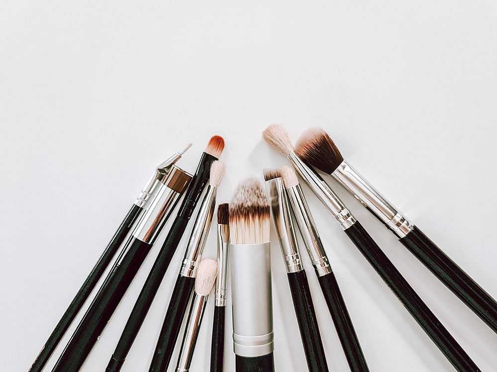 Various makeup brushes arranged in a semi-circle on a white background.